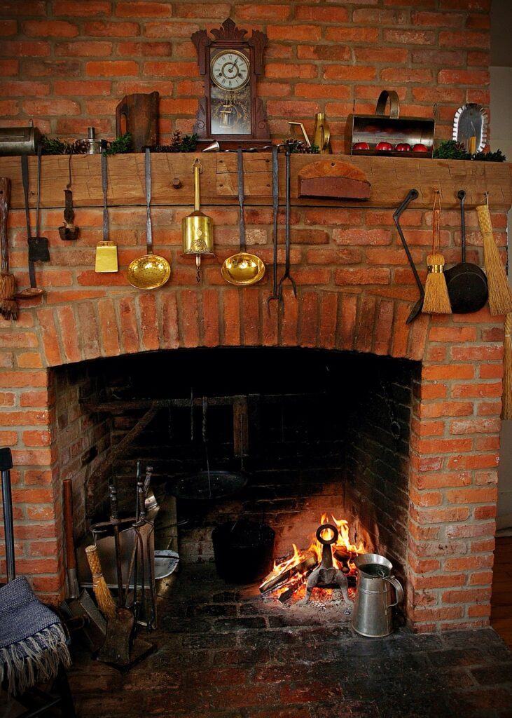 Brick fireplace. Cooking ladles hung above the fire.